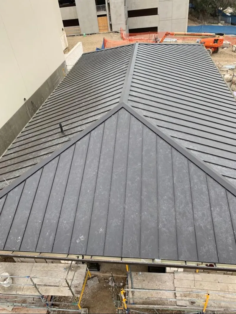 Commercial metal roof construction with crane equipment in Garrison